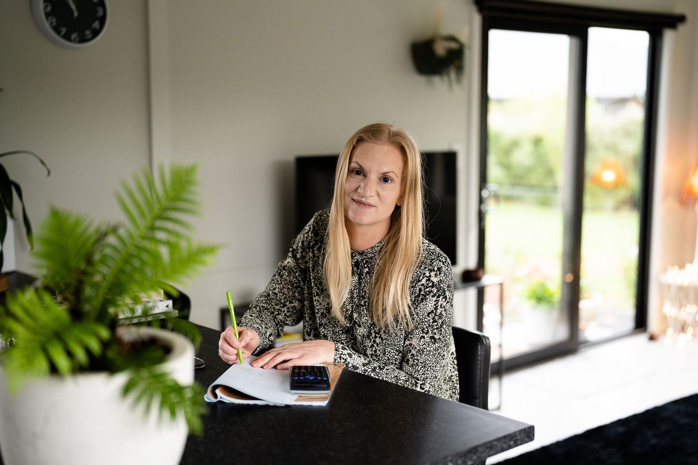 Sarah Curley sitting at her desk with a notebook